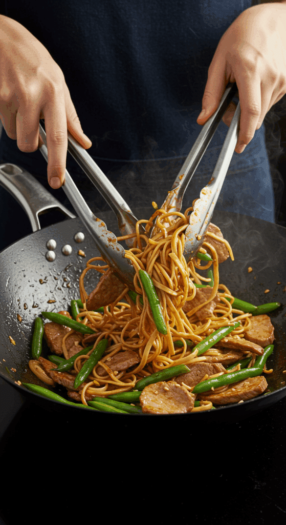 Tossing the finished Thai Pork and Noodles together in a hot wok.