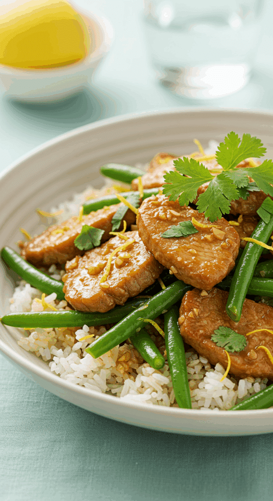 A vibrant bowl of Pork and Green Bean Stir-Fry served over fragrant lemon rice.