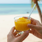 A person holding a refreshing glass of Mango Sago on a sunny, tropical vacation.