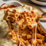 A cheesy scoop of the Chicken Sausage Pasta Fake-Bake being served from the dish.