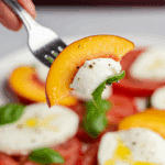 A forkful of the finished, fresh Peach Caprese Salad.