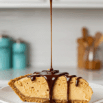 A hand drizzling rich chocolate syrup over a perfect slice of Easy Peanut Butter Pie.