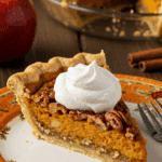 A beautiful, layered slice of the "three-in-one" Apple-Pumpkin-Pecan Pie being served for a holiday dessert.