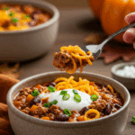 A cozy bowl of homemade Turkey Chili with Butternut Squash Noodles, topped with sour cream, being served for a family dinner.