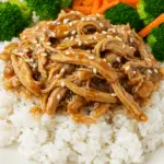 A beautiful and healthy rice bowl topped with a generous serving of homemade Slow Cooker Honey Teriyaki Chicken and steamed broccoli.