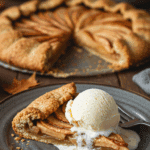 A perfect slice of warm, homemade Apple Galette served with a large scoop of melting vanilla ice cream.