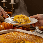 A beautiful, golden-brown, homemade Corn Casserole in a baking dish with a creamy scoop being lifted out.