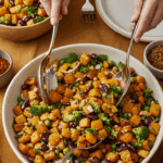 Serving a large scoop of the vibrant Roasted Butternut Squash Salad at a festive holiday dinner.
