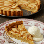 An elegant slice of French Apple Tart being served with a scoop of vanilla ice cream for dessert.