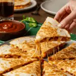 A large platter of homemade, cheesy BBQ Chicken Quesadillas being served at a fun and casual family dinner.