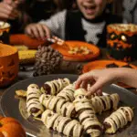A large platter of homemade, spooky, and adorable Banana Mummies being served at a fun and casual Halloween party.