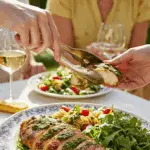 A beautiful platter of homemade Chicken with Arugula Pesto being served at a sunny, outdoor dinner party.