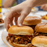 A large platter of homemade, messy, and delicious Chipotle Sloppy Joes being served at a fun family barbecue.