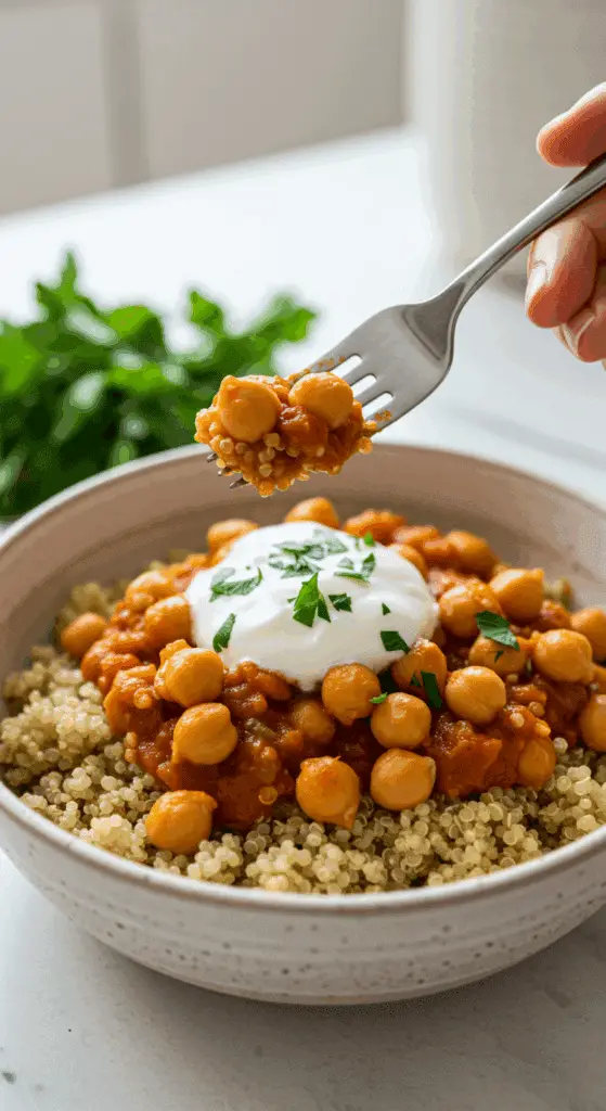 A beautiful bowl of homemade, healthy Lemony Chickpeas being served over a bed of quinoa for a delicious weeknight dinner.