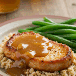 A classic dinner plate with a thick, saucy pork chop served over a bed of brown rice with a side of green beans.