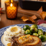A beautiful plate of homemade Baked Pork Chops with a generous portion of applesauce glaze, served with mashed potatoes for a cozy meal.