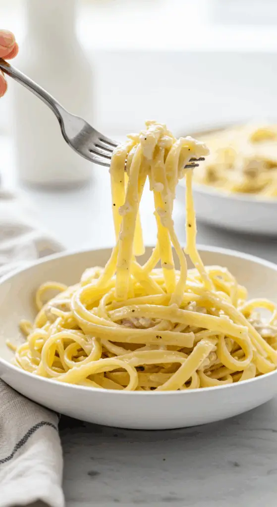 An elegant plate of homemade, creamy Cauliflower Chicken Alfredo being enjoyed for a healthy and satisfying weeknight dinner.