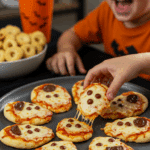 A large platter of homemade, spooky, and adorable Ghost Pizzas being served at a fun and casual Halloween party.