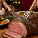 The whole, homemade, impressive, and crusted Prime Rib being carved as the centerpiece at a fun and sophisticated Christmas party.