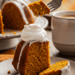 A beautiful slice of homemade, moist, and glazed Pumpkin Bundt Cake being enjoyed with a fork and a cup of coffee on a cozy fall morning.