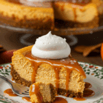 A beautiful plate with a homemade, festive, and creamy slice of a Pumpkin Cheesecake being served for a holiday dessert.