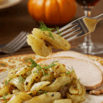 A beautiful plate of a homemade, elegant, and golden-brown Roasted Fennel with Parmesan, being served with a thick slice of a roasted turkey at a Thanksgiving dinner.