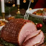 The whole, homemade, impressive, and glazed Spiral-Cut Ham being served as the centerpiece at a fun and sophisticated Christmas party.