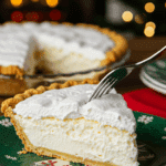 A beautiful plate with a homemade, festive, and airy slice of a "White Christmas Pie" being served for a holiday dessert.